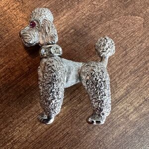 This Vintage Silver-tone signed NAPIER Poodle Pin with Rotating head, pink eyes
